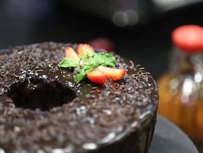 Ein Schokoladenkuchen mit Erdbeeren und Minzblättern.