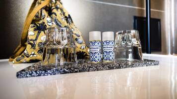Una encimera de baño con dos botellas de champú, dos vasos y una toalla.