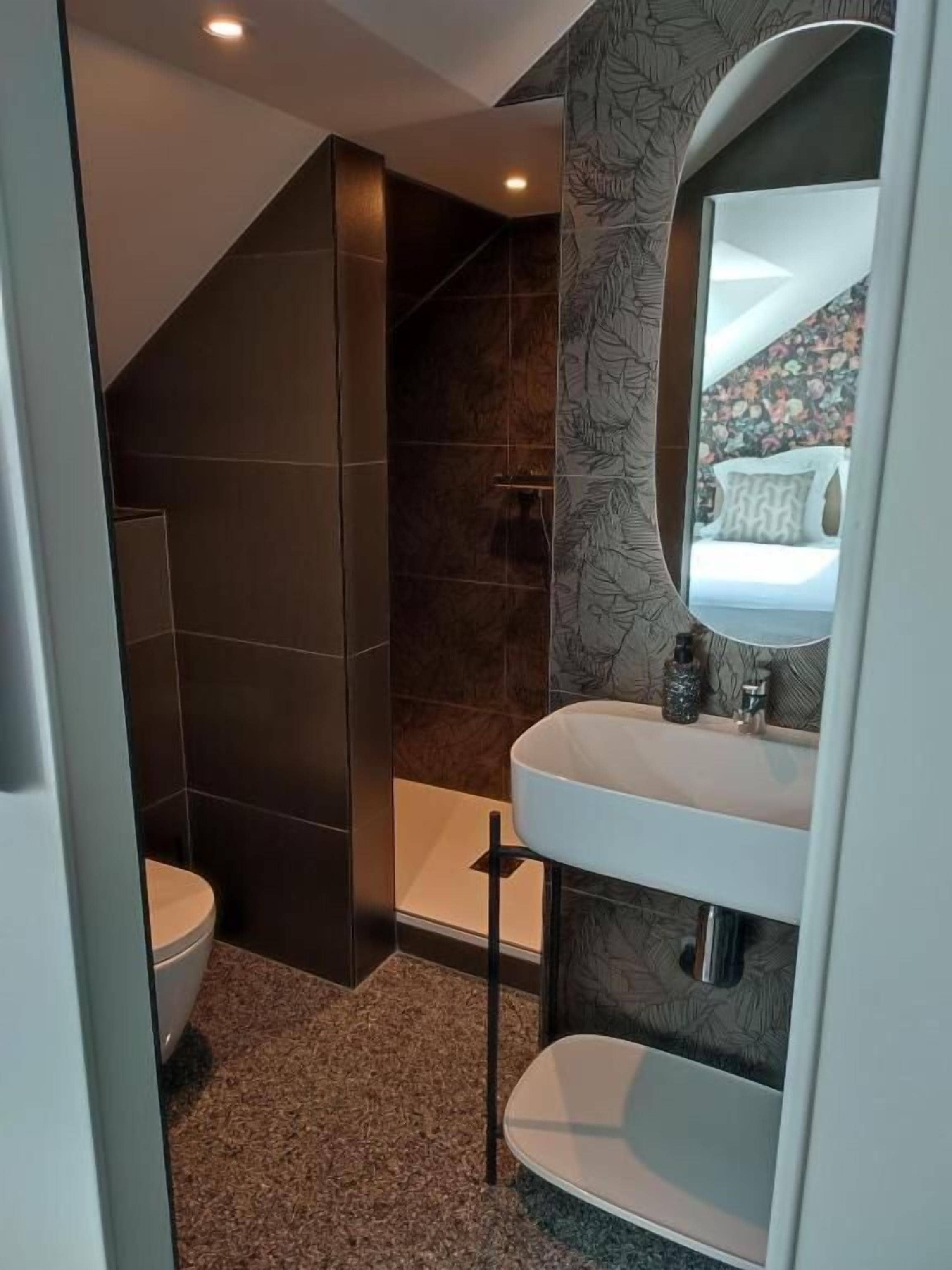 A modern bathroom with a toilet, sink, and shower.
