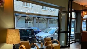 Un interior moderno con una zona de estar, una lámpara y vistas a coches aparcados afuera.