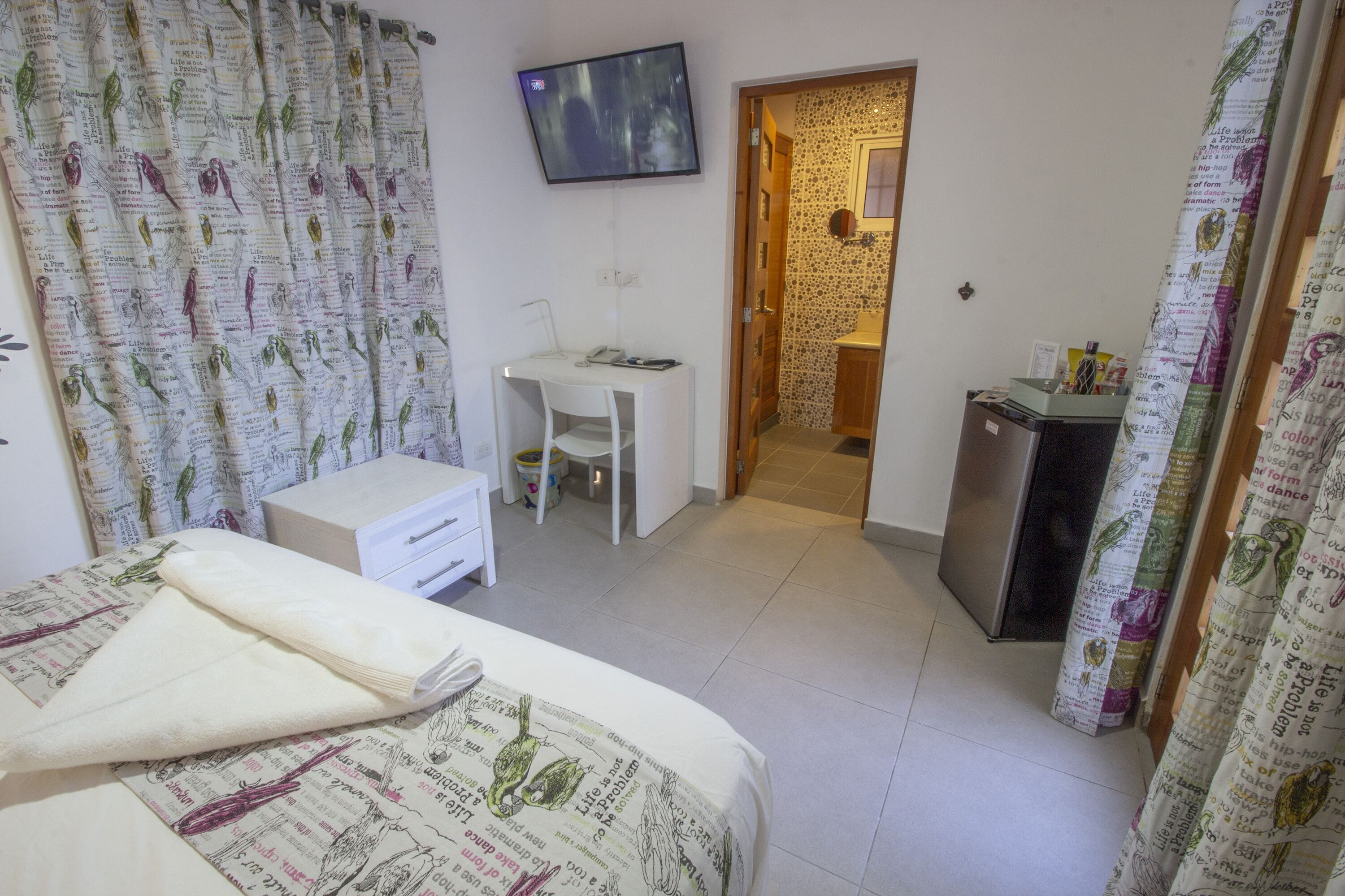 Une chambre à coucher avec un lit, un bureau et un téléviseur.