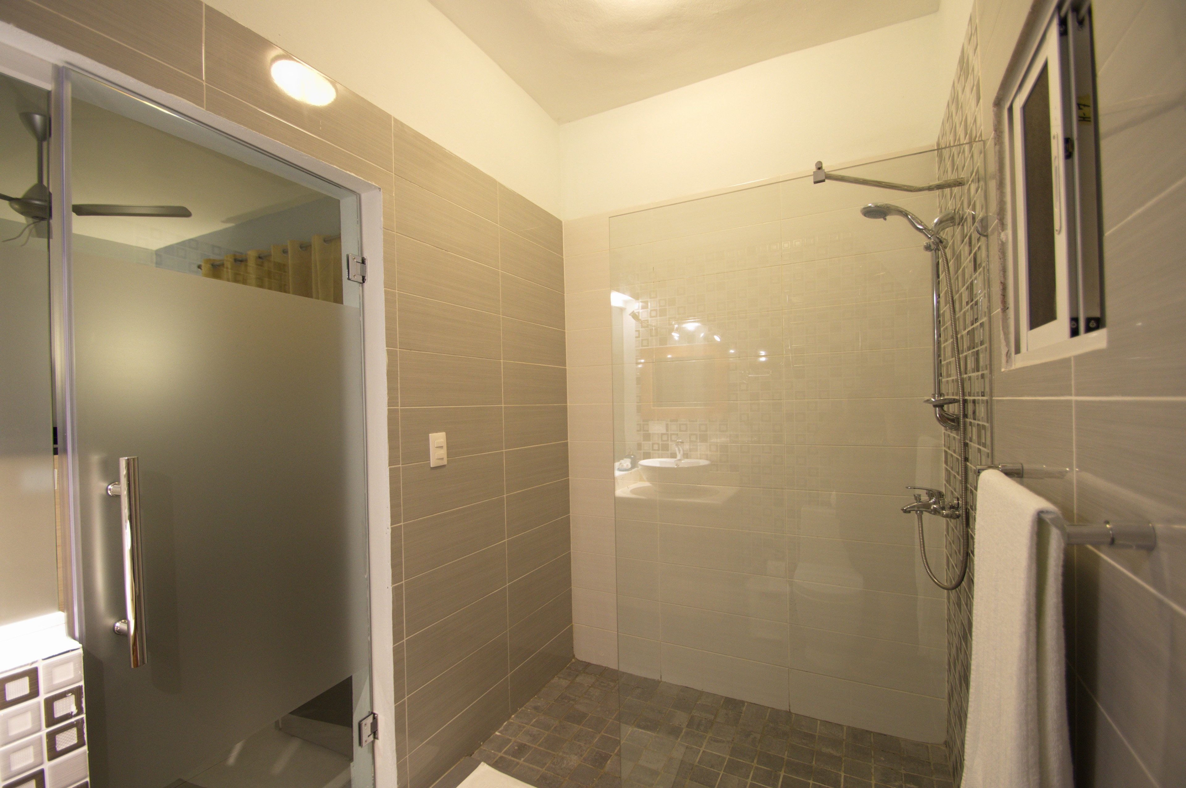 A modern bathroom with a glass shower enclosure, a visible sink, and a towel rack.