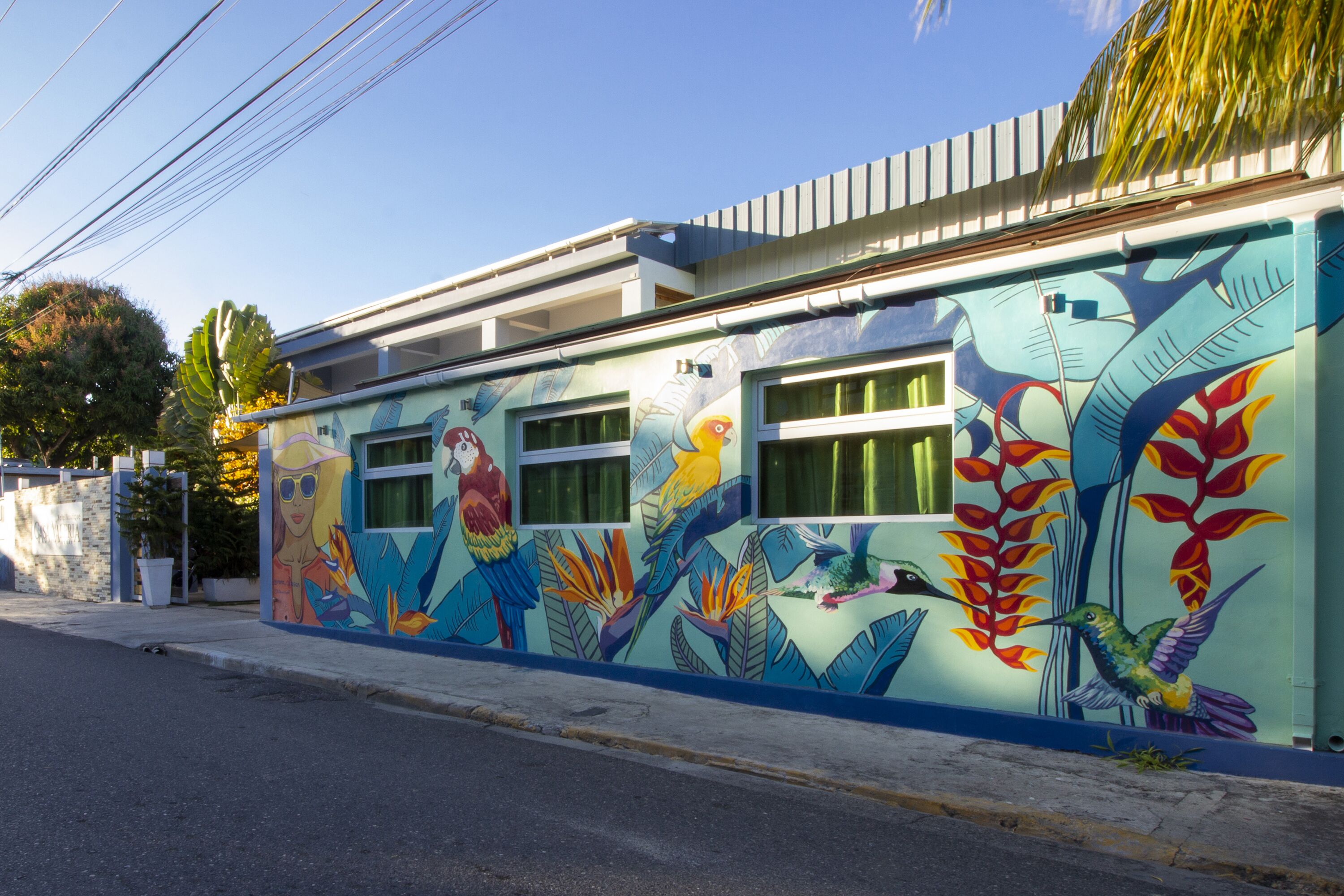 A building with a colorful mural featuring tropical birds and plants.