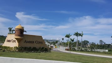 A sign for Amber Cove with a clear sky and palm trees in the background.