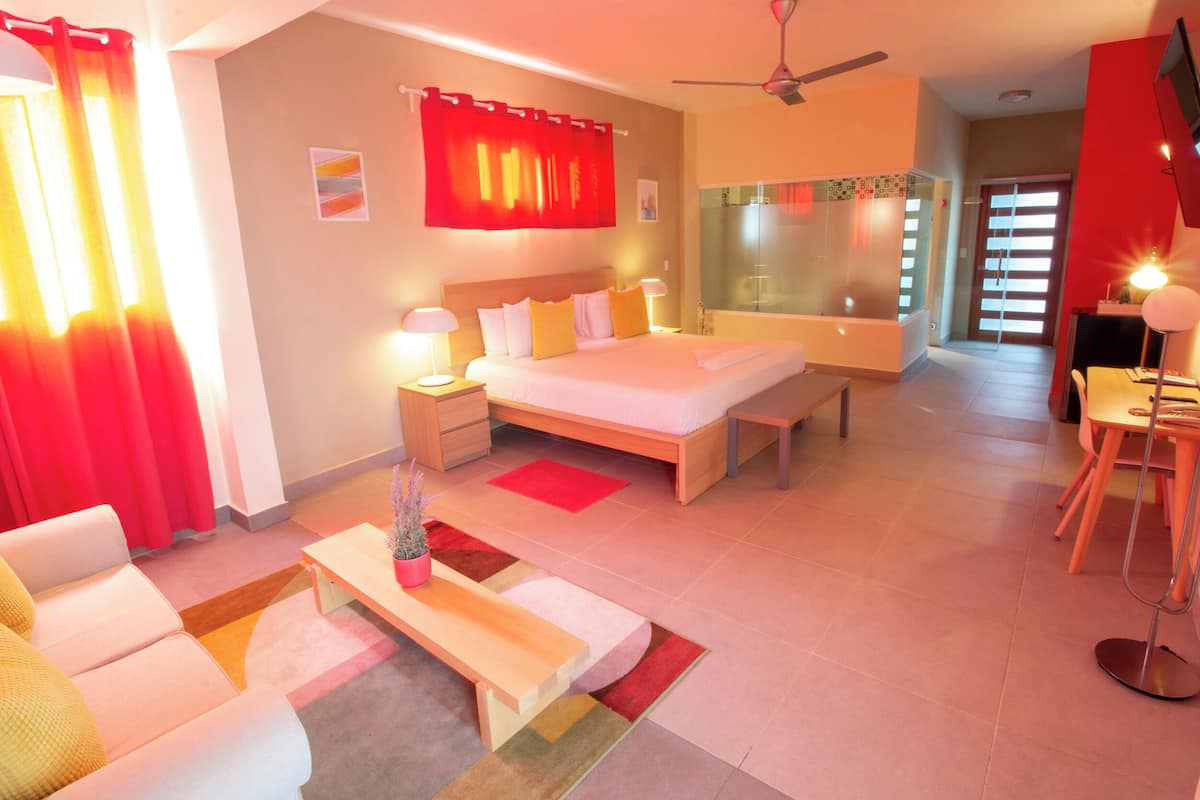 Ein modernes Hotelzimmer mit einem großen Bett, Nachttischen, einem Schreibtisch und einem Sessel.
