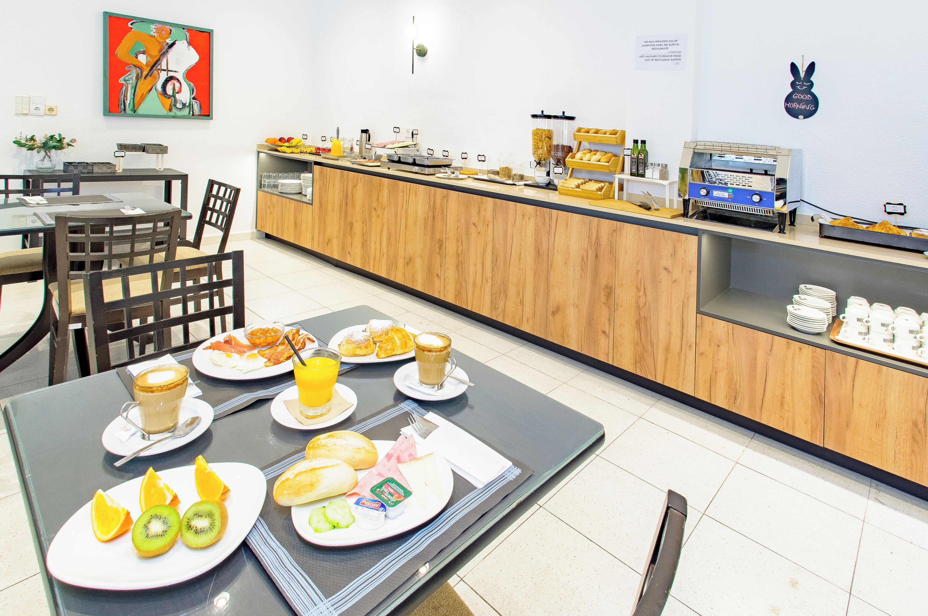 Buffet de l'esmorzar amb diverses plats i una màquina de cafè.