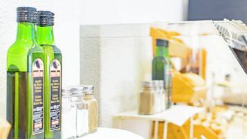 Bottles of olive oil and salt shakers on a table.