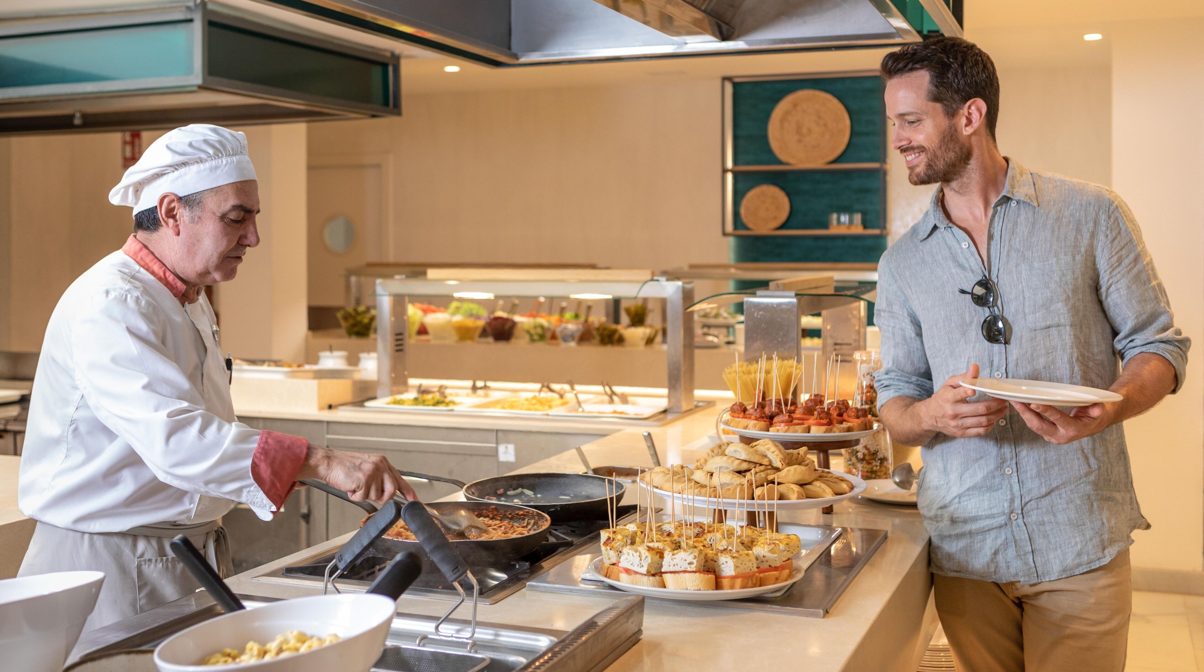 A buffet setup with various food items and a person serving food.