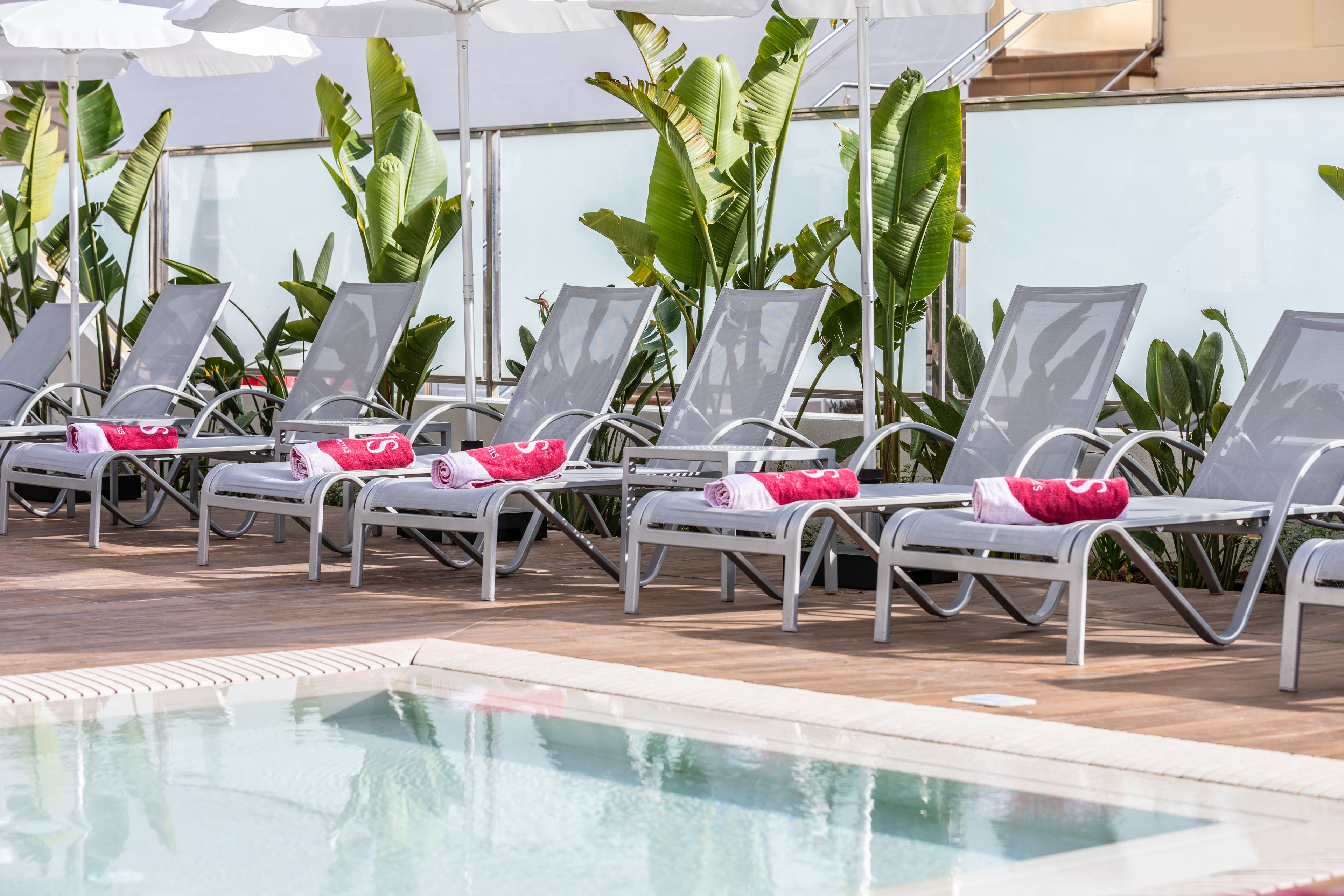 A poolside area with lounge chairs and umbrellas.