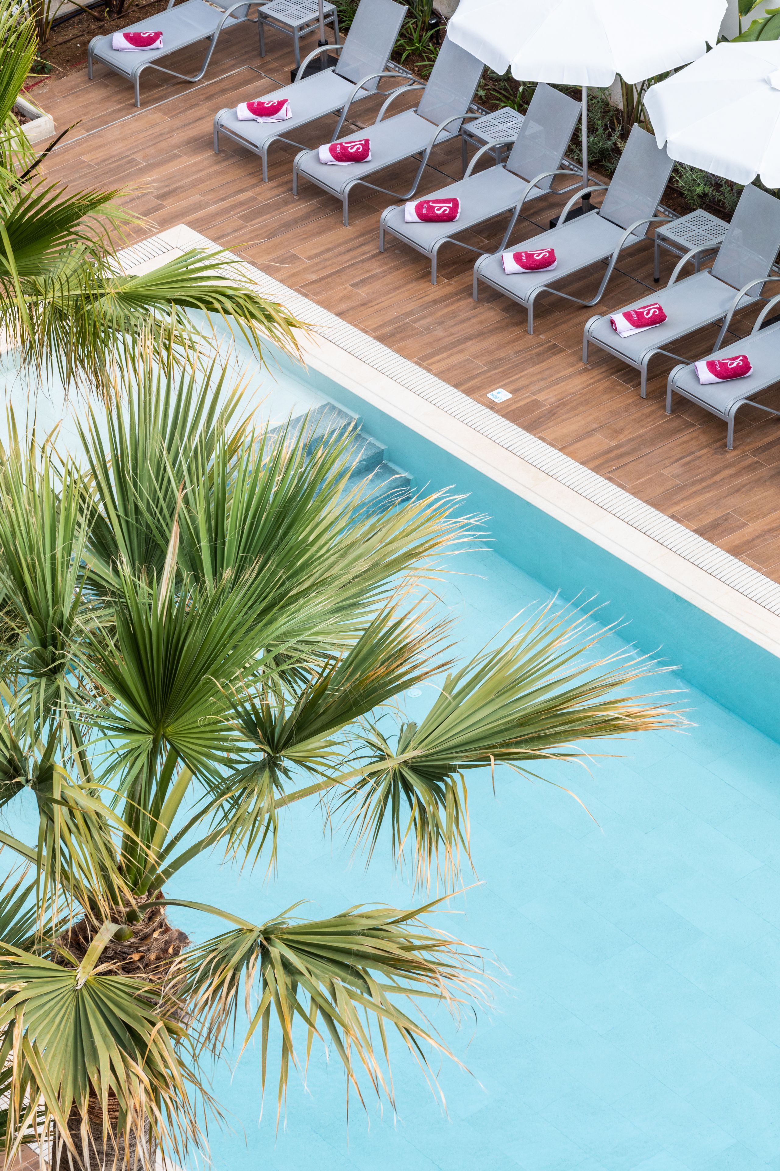 A poolside area with lounge chairs and umbrellas.