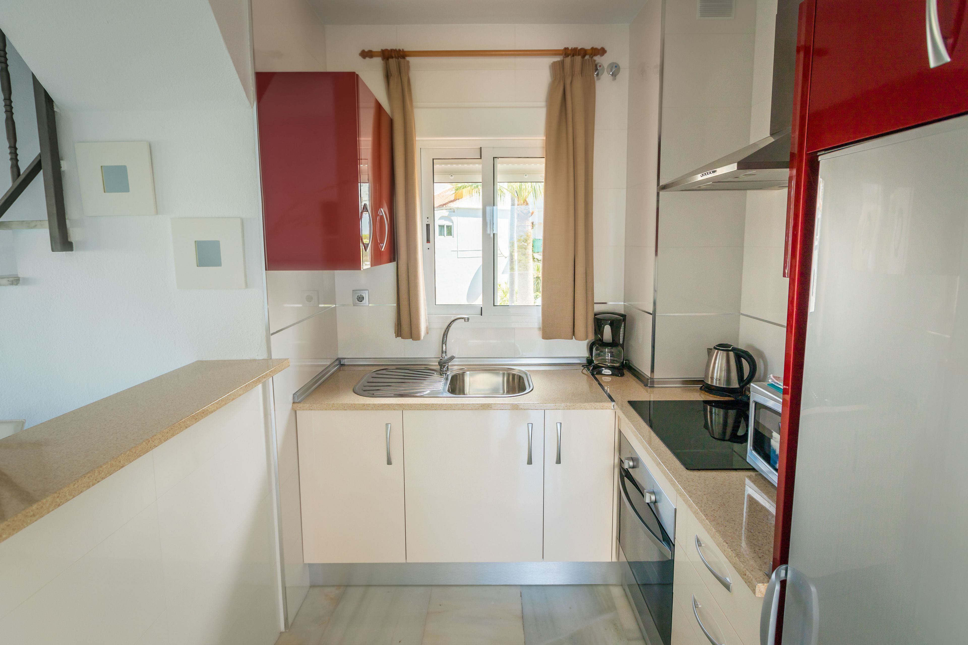 Eine kleine Küche mit Spüle, Herd und Kühlschrank.