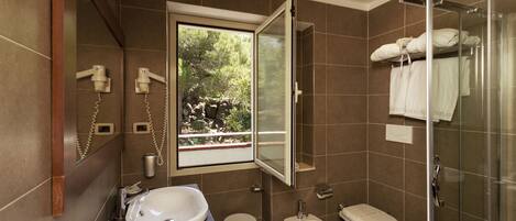 A modern bathroom with a large window, a bathtub, a shower, and a toilet.