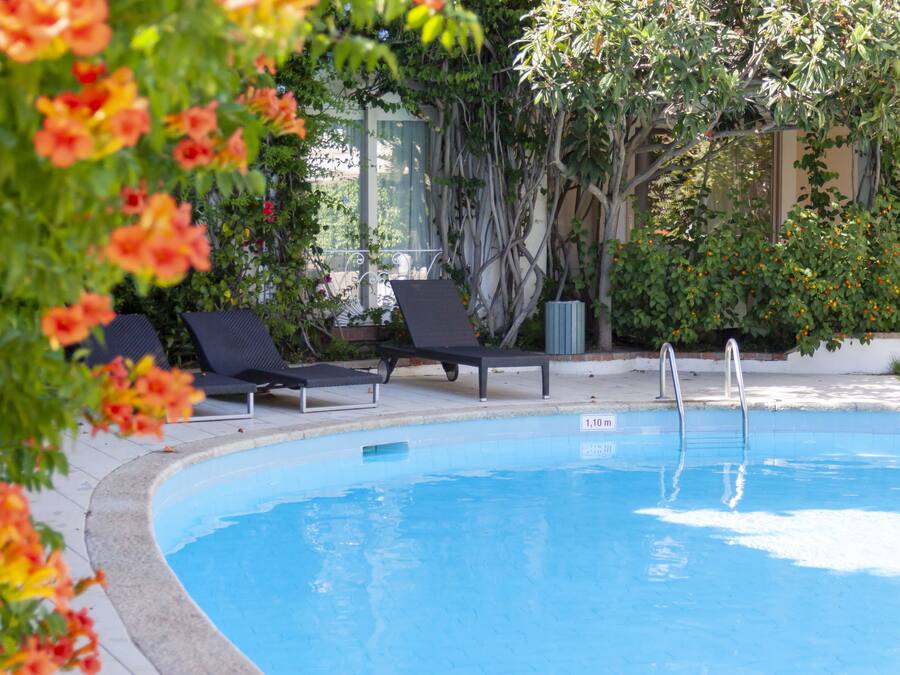 A swimming pool with lounge chairs, a metal ladder, and a 1.10m depth marker.