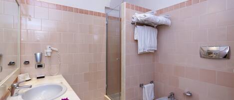 Ein Badezimmer mit einem Waschbecken, einer Dusche und einer Toilette.