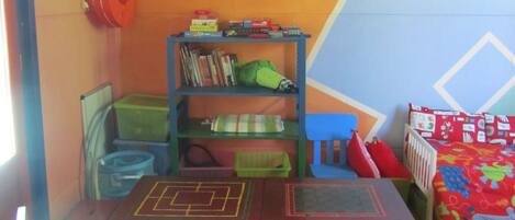 A children's play area with a table, chairs, and a bookshelf.