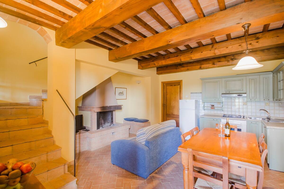 Une cuisine chaleureuse avec une table et des chaises en bois, un four encastré et des armoires bleu clair.