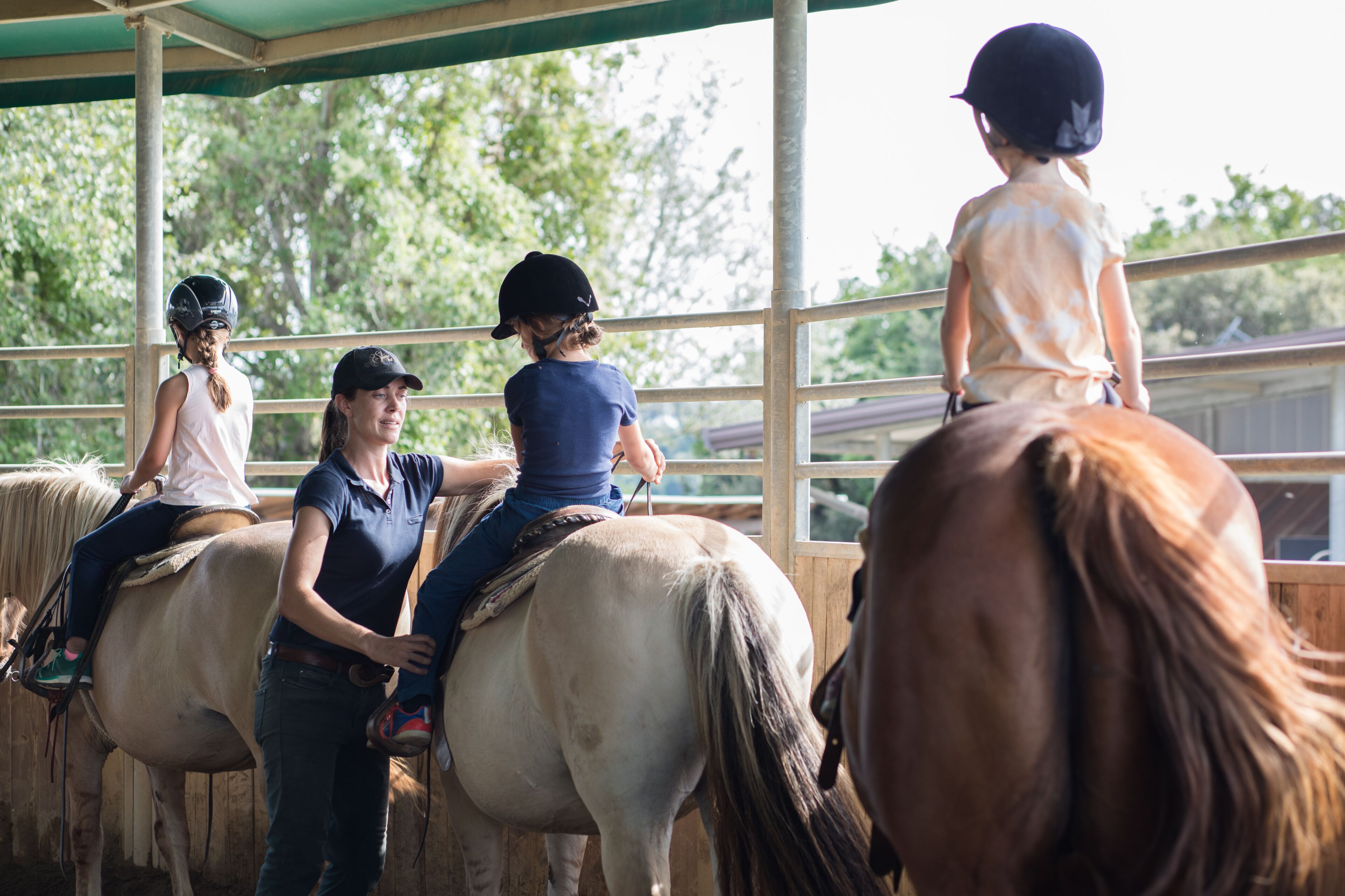 A stable with four horses and riders.
