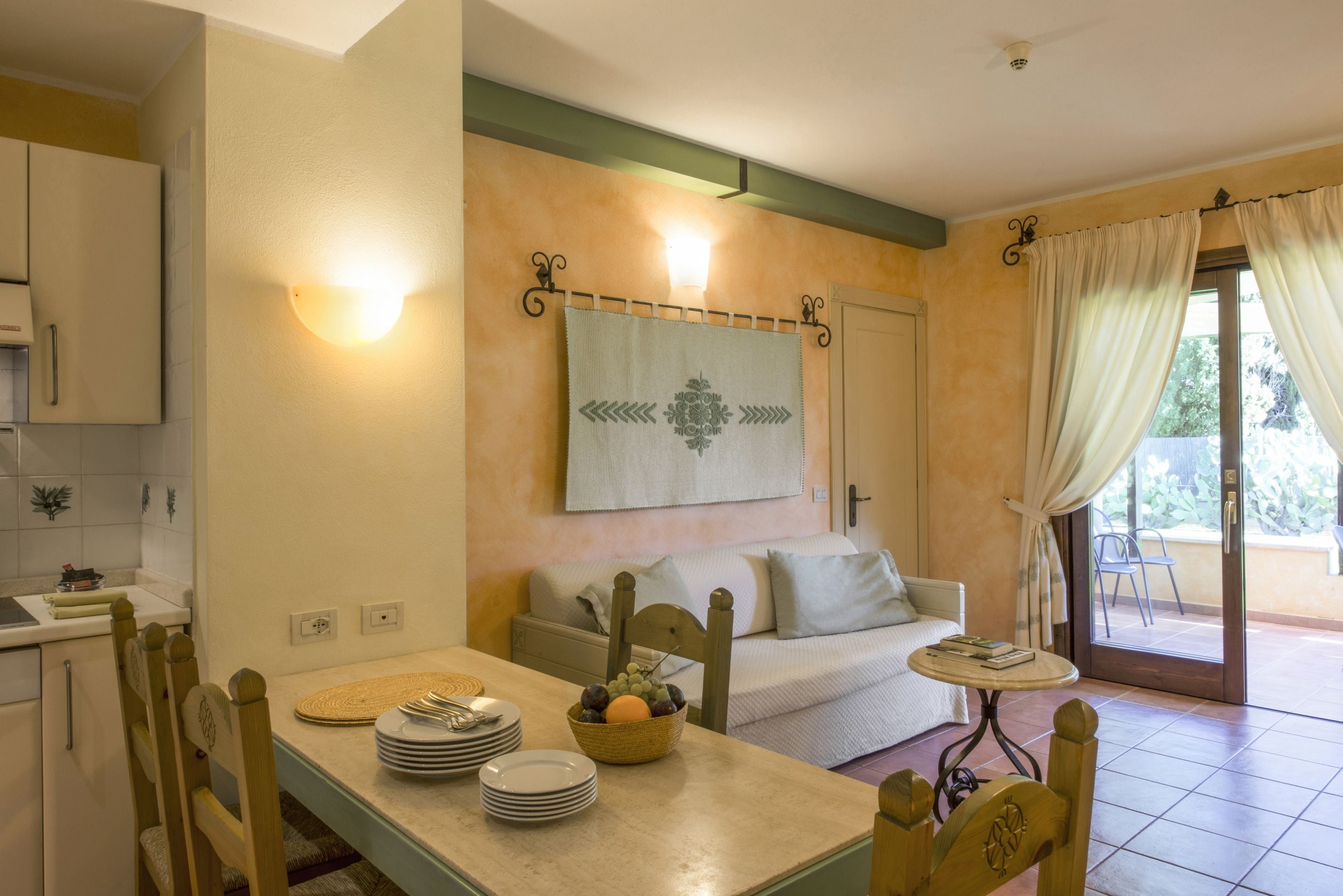 A cozy room with a dining table, chairs, a sofa, and a small table with a book.