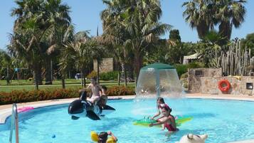 Enjoy a refreshing swim in our pool surrounded by lush greenery.