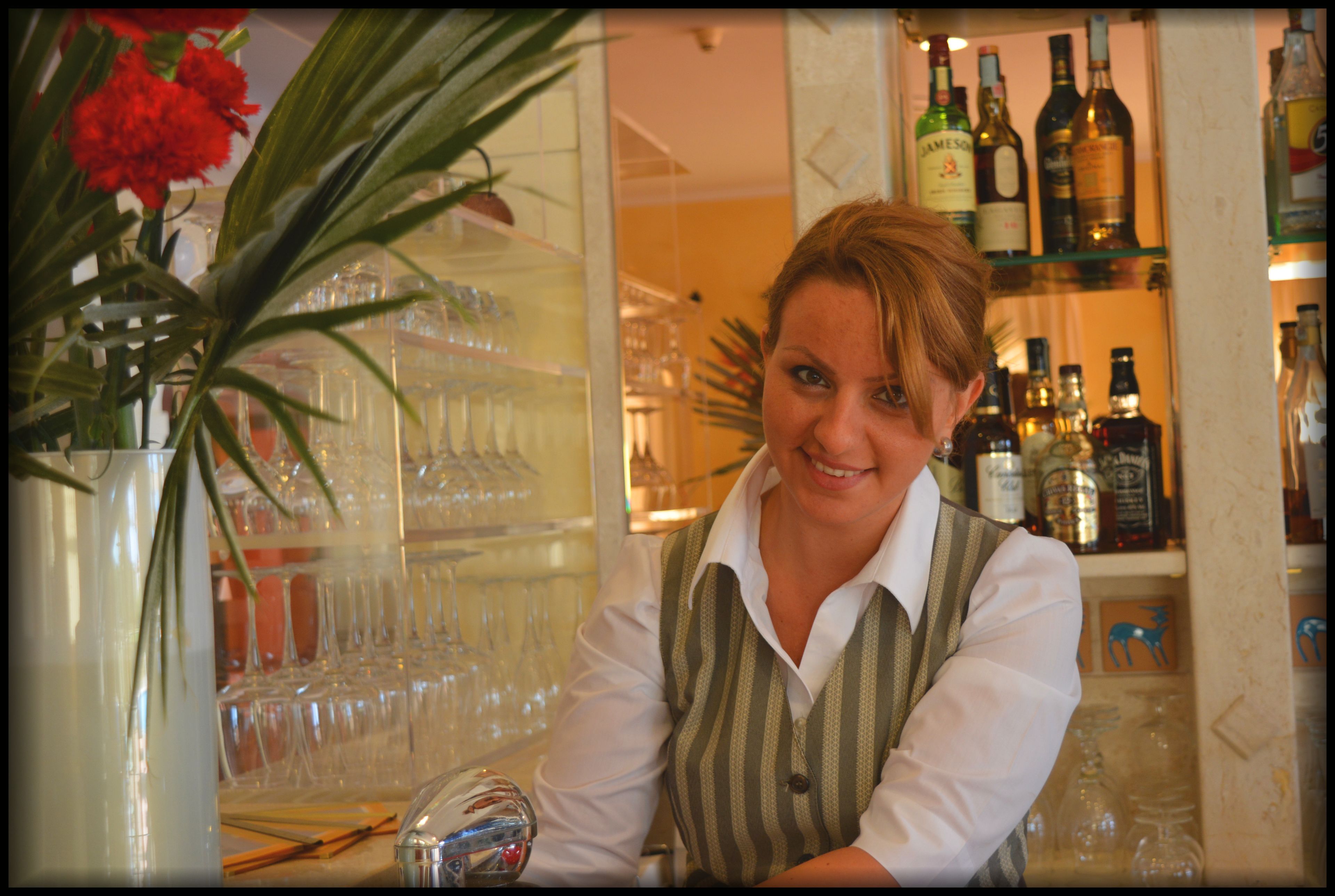 Un espace bar avec des étagères remplies de bouteilles et de verres.