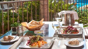 A dining table with plates of food, glasses of wine, and a bottle of champagne. - Vale Do Garrão Villas (Loulé)
