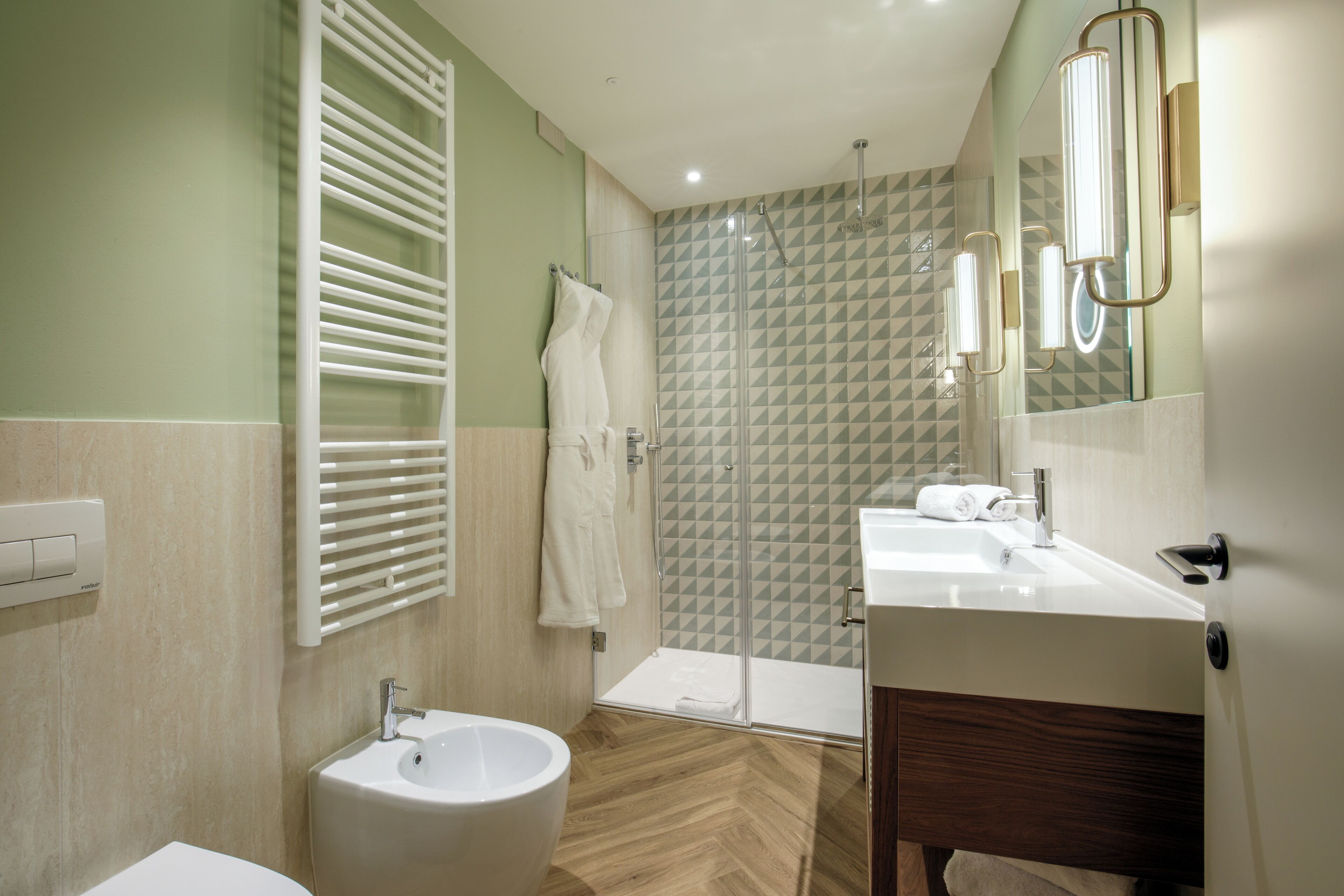 Un baño moderno con lavamanos, inodoro y zona de ducha.