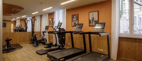Un gimnasio con cintas de correr, bicicletas estáticas y máquinas elípticas.