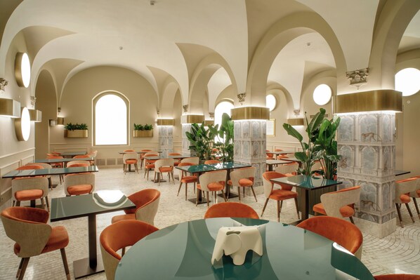 A dining area with tables and chairs, arched ceilings, and potted plants. - Rosetta Hotel Perugia, Tapestry Collection by Hilton (Perugia)