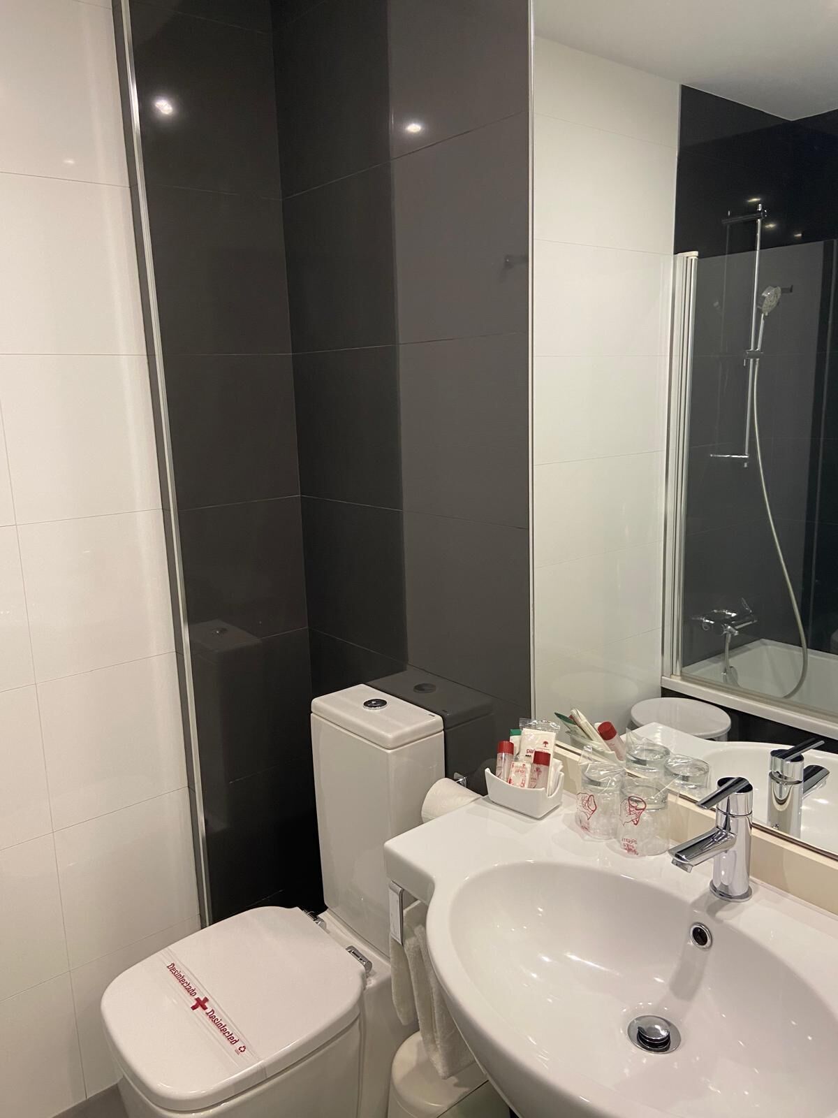 Ein modernes Badezimmer mit Toilette, Waschbecken und Dusche.