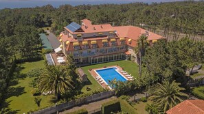 A large, multi-story building with a swimming pool and outdoor seating area.