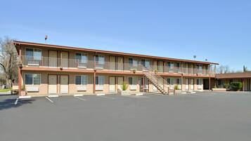A motel with a central staircase, multiple rooms, and a parking lot.