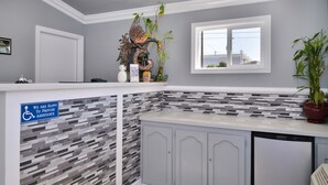 A kitchen with grey cabinets, a tiled backsplash, and a window with a view.