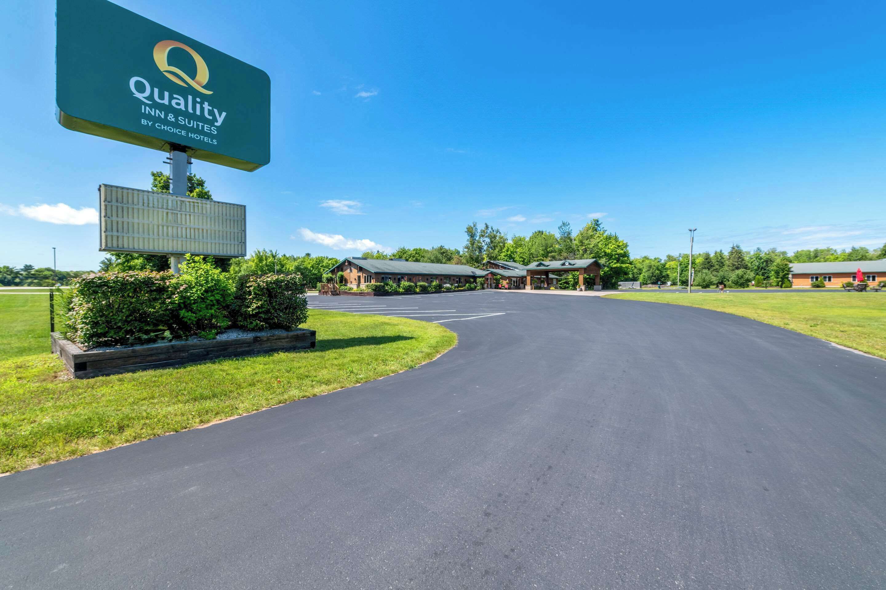 A Quality Inn & Suites sign, a paved driveway, and a building complex with multiple structures.