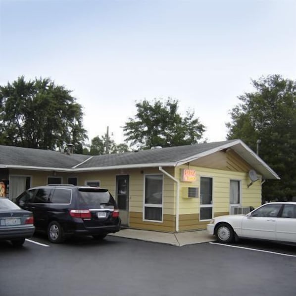 A motel with a single-story structure, a small attached garage, and a neon sign indicating a restaurant. - Viking Jr. Motel (Saint Peter)