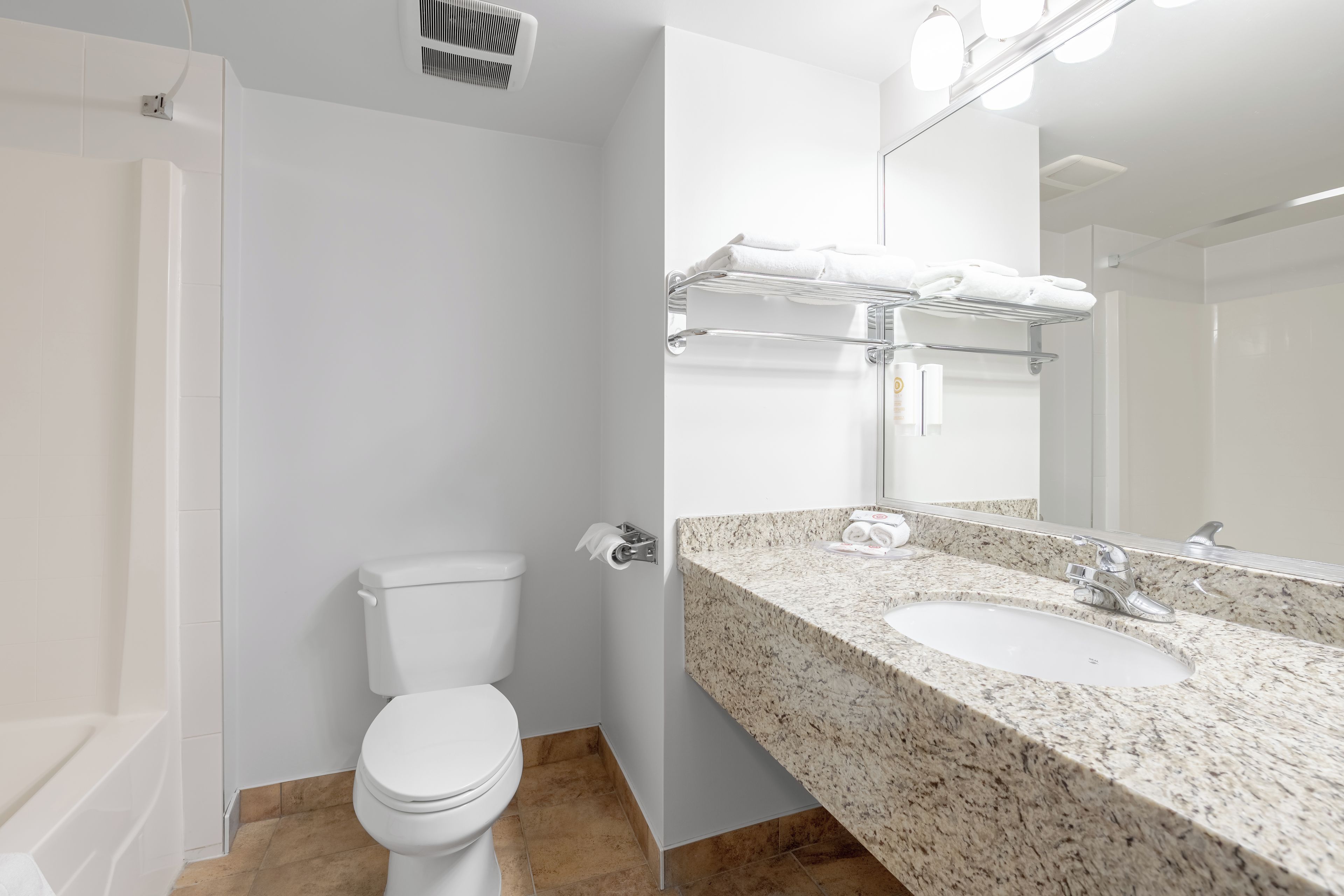 Uma casa de banho moderna com sanita, lavatório e porta-toalhas.