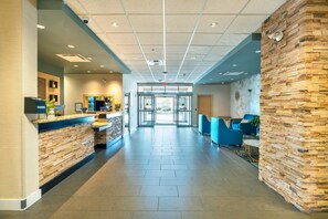 A hotel lobby with a reception desk, seating area, and a view of the outside. - Comfort Inn & Suites Surrey (Surrey)