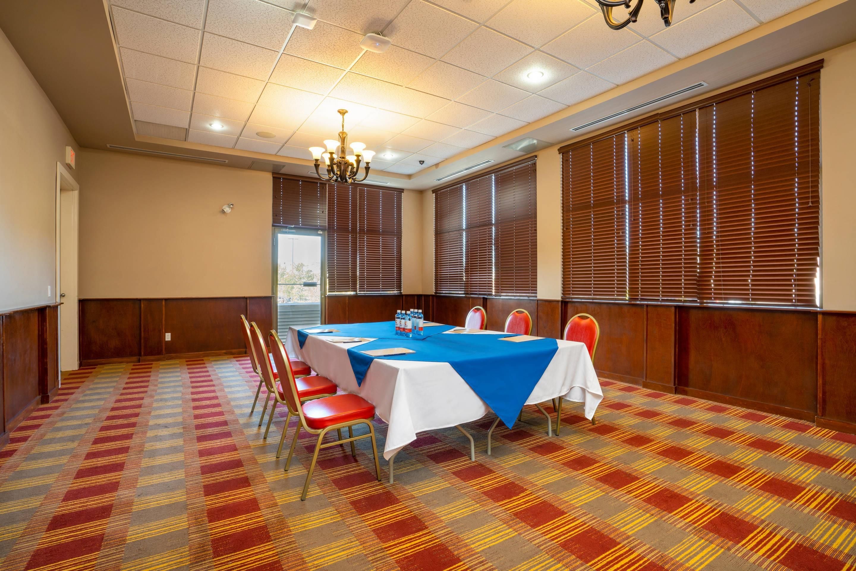 A conference room with a large table, chairs, and a chandelier.