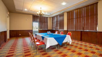 A conference room with a large table, chairs, and a chandelier.