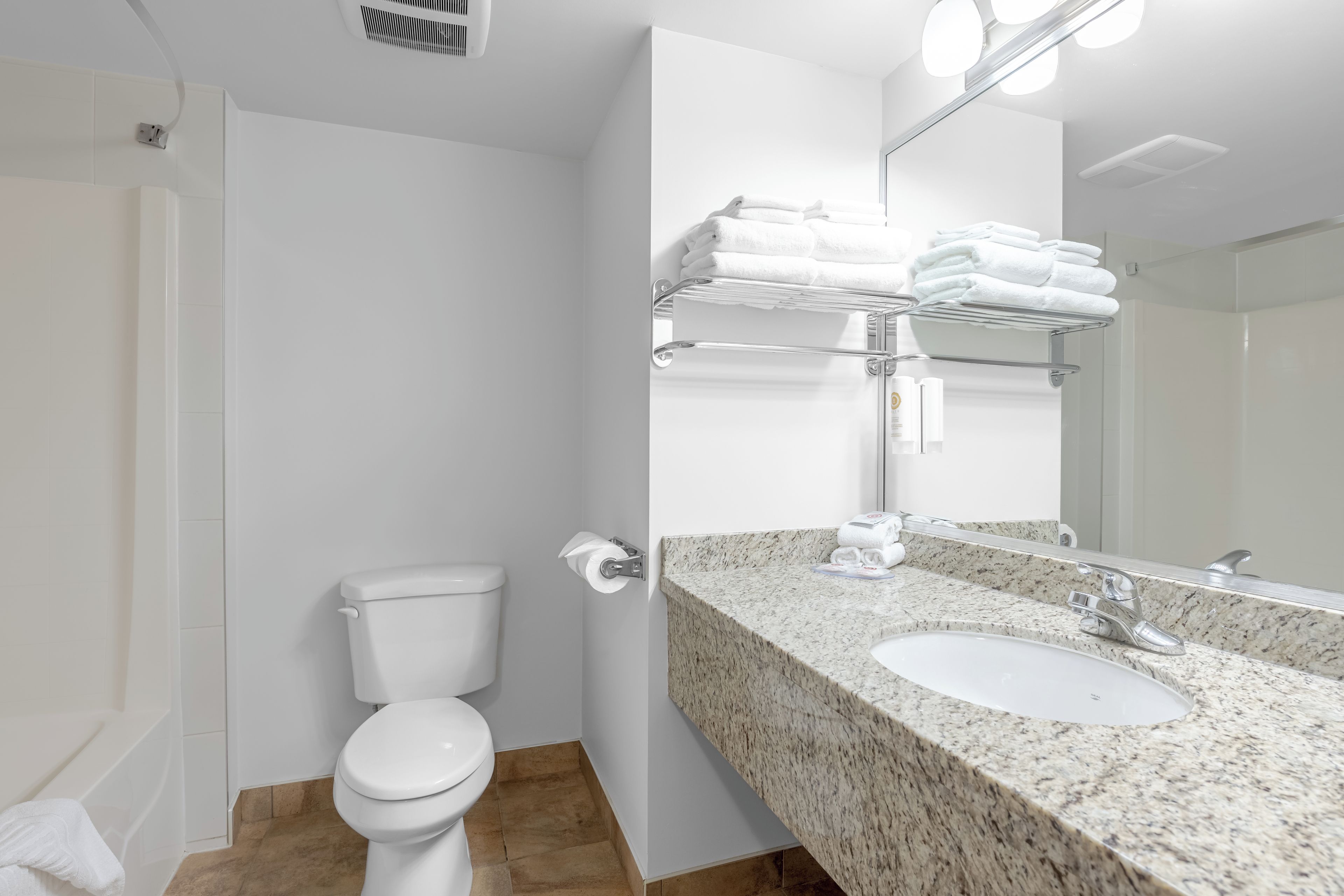 A modern bathroom with a toilet, sink, and towel rack.
