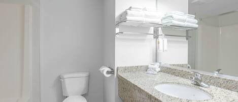 A modern bathroom with a toilet, sink, and towel rack.