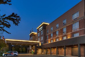 A hotel with a modern brick facade, a well-lit entrance, and a parking area. - Comfort Inn & Suites Surrey (Surrey)