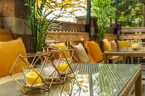 A dining area with a glass table, yellow cushions, and a geometric metal frame. - Comfort Inn & Suites Surrey (Surrey)
