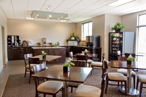 A spacious kitchen with modern appliances, wooden furniture, and a large window providing natural light.