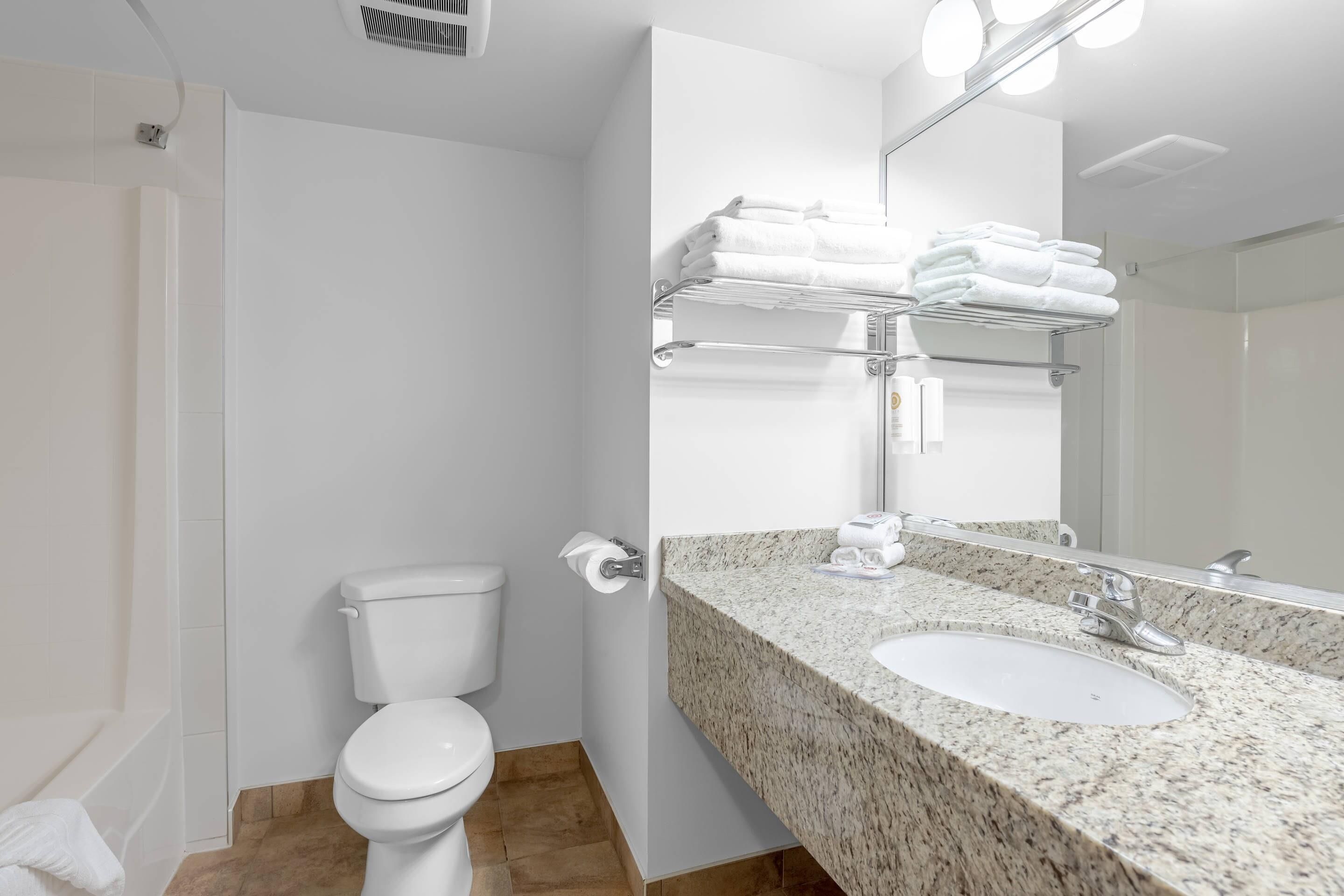 A modern bathroom with a toilet, sink, and towel rack.