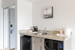 A modern kitchen with a dishwasher, a coffee maker, a microwave, and a sink. - Comfort Inn & Suites Surrey (Surrey)