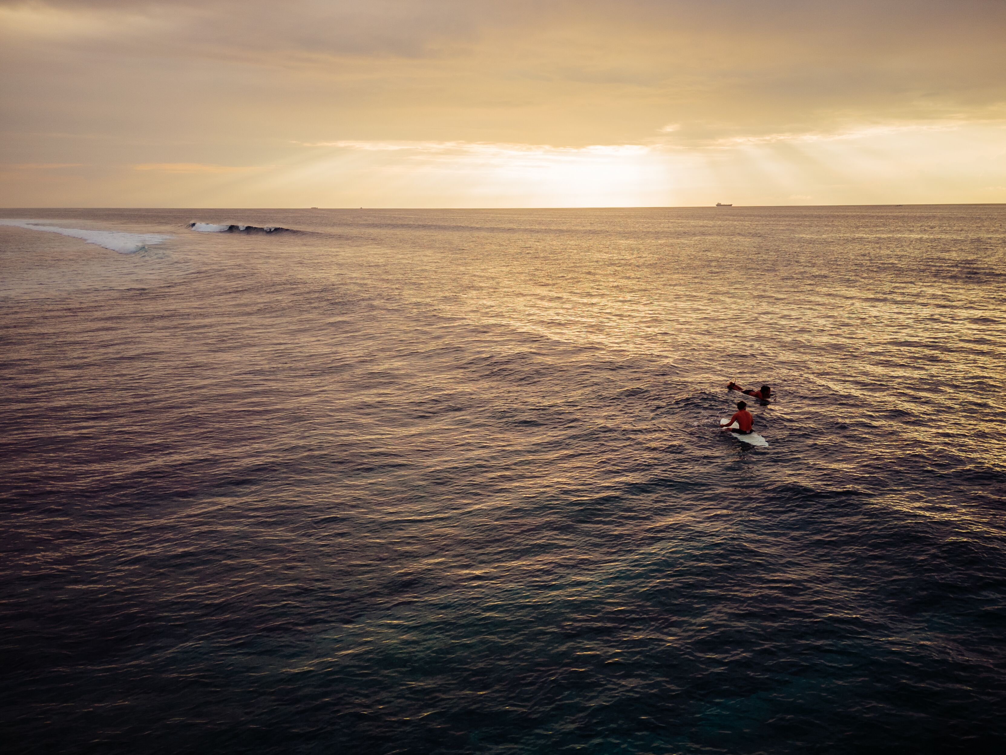 A beach scene with waves and a person surfing.