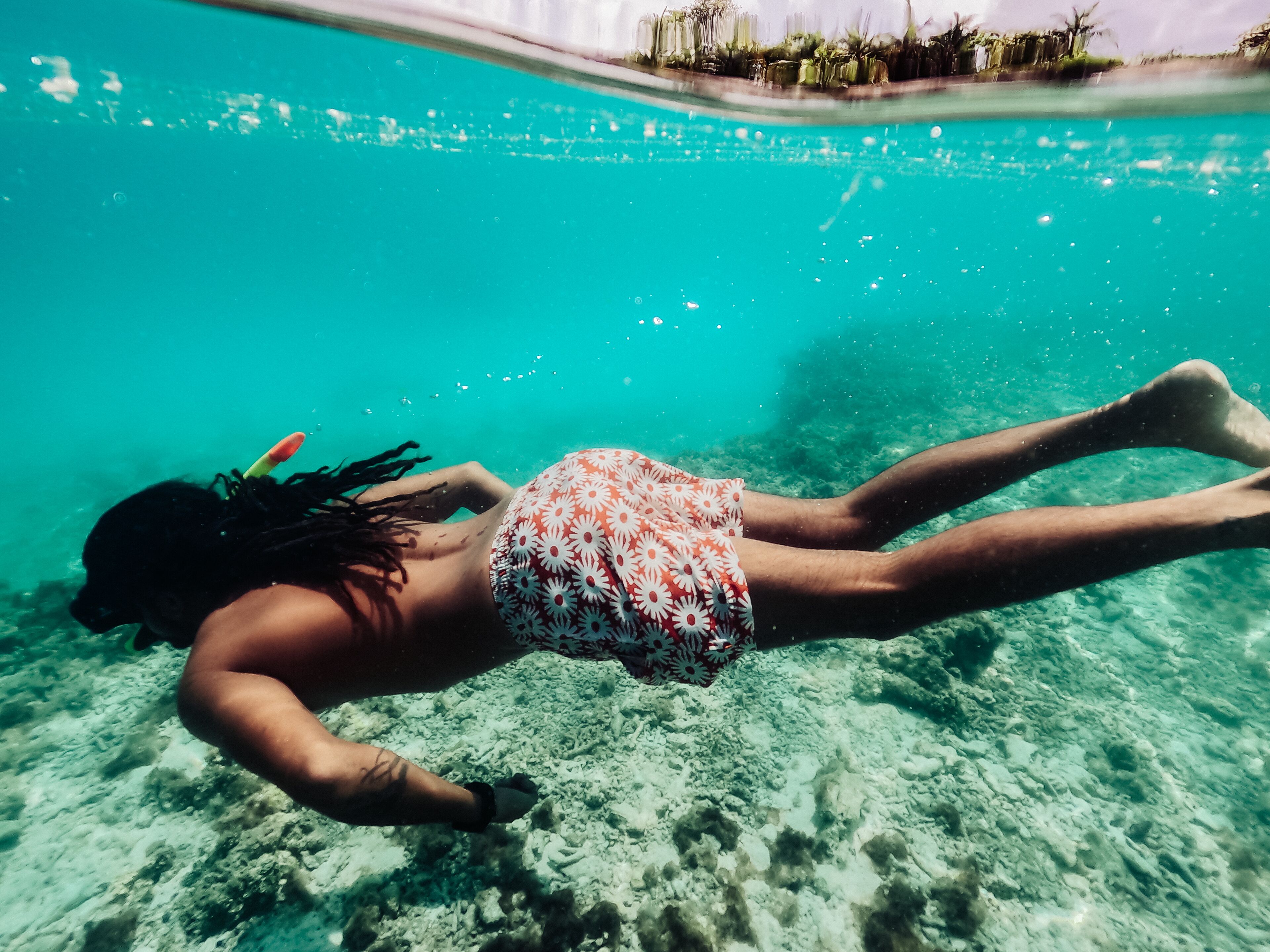 Une personne nageant sous l’eau dans une piscine.