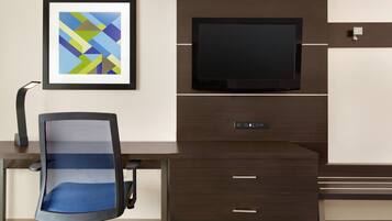 A modern office setup with a desk, chair, mounted TV, and a framed abstract artwork.