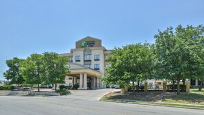 A Holiday Inn Express hotel with a large entrance, surrounded by trees and a well-maintained lawn. - Holiday Inn Express & Suites San Antonio NW - Medical Area by IHG (San Antonio)