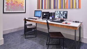 A modern office space with a long desk, two chairs, two monitors, a printer, and a framed abstract painting on the wall. - Holiday Inn Express & Suites San Antonio NW - Medical Area by IHG (San Antonio)